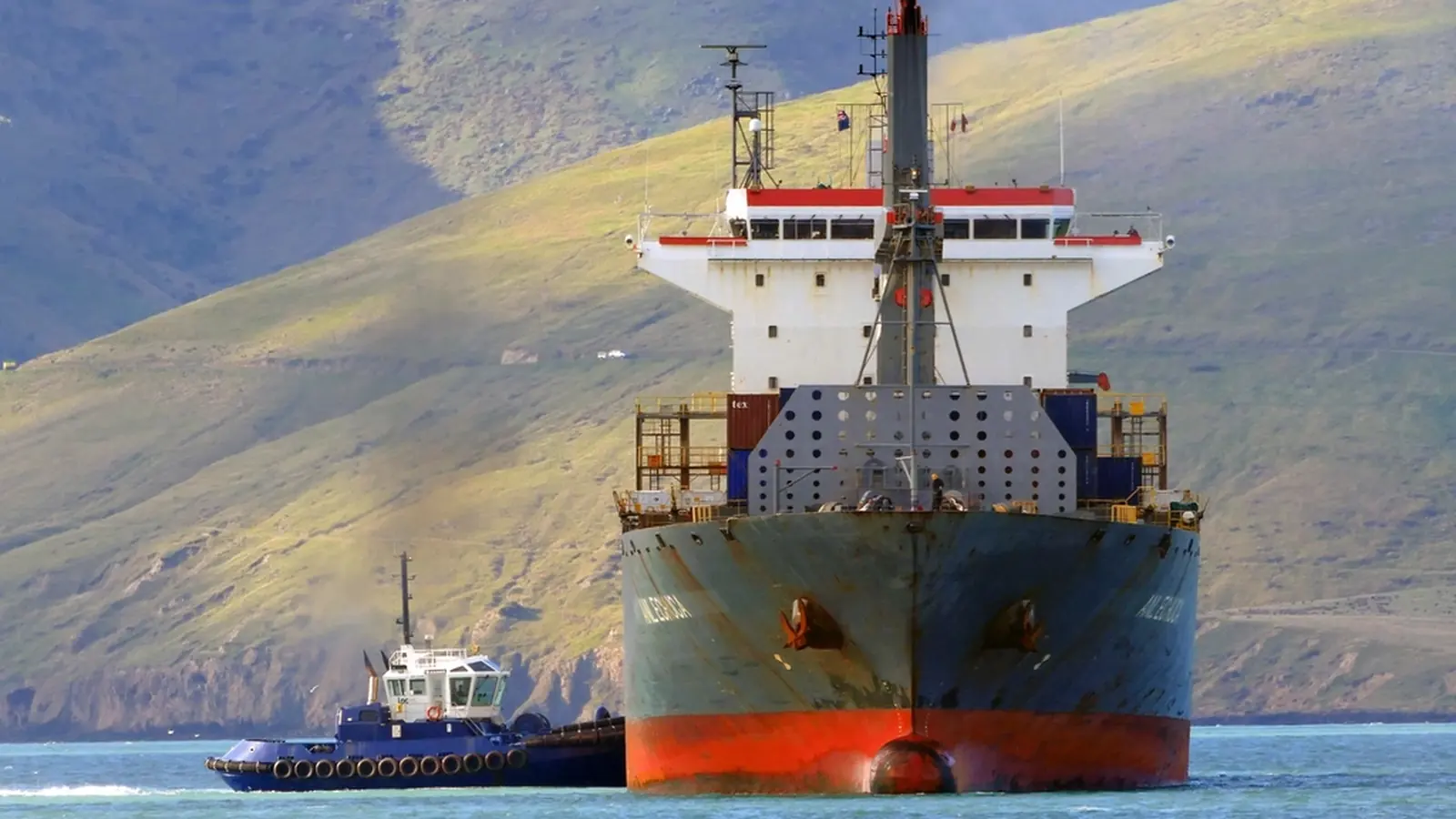 Container ship bow on, guided by a tugboat
