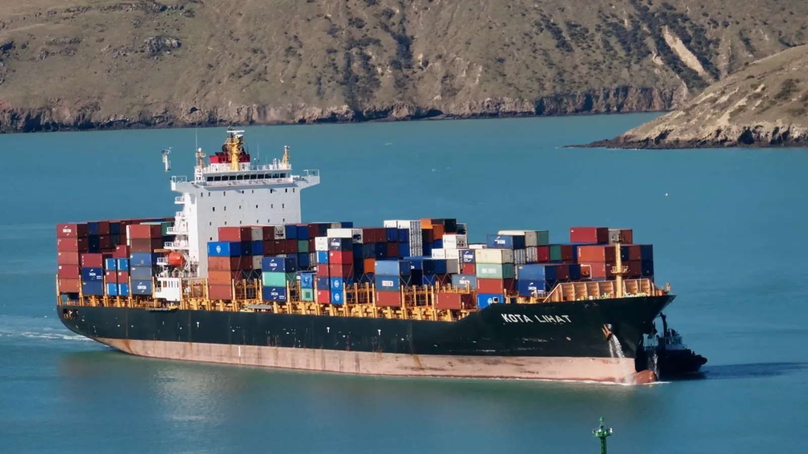Container ship under way in blue coastal water
