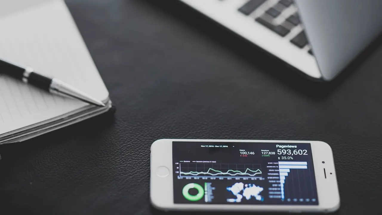 Phone showing an analytics dashboard next to a laptop