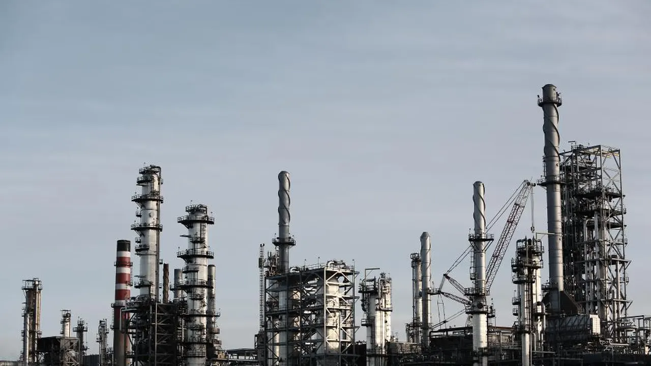 Oil refinery towers against a grey sky