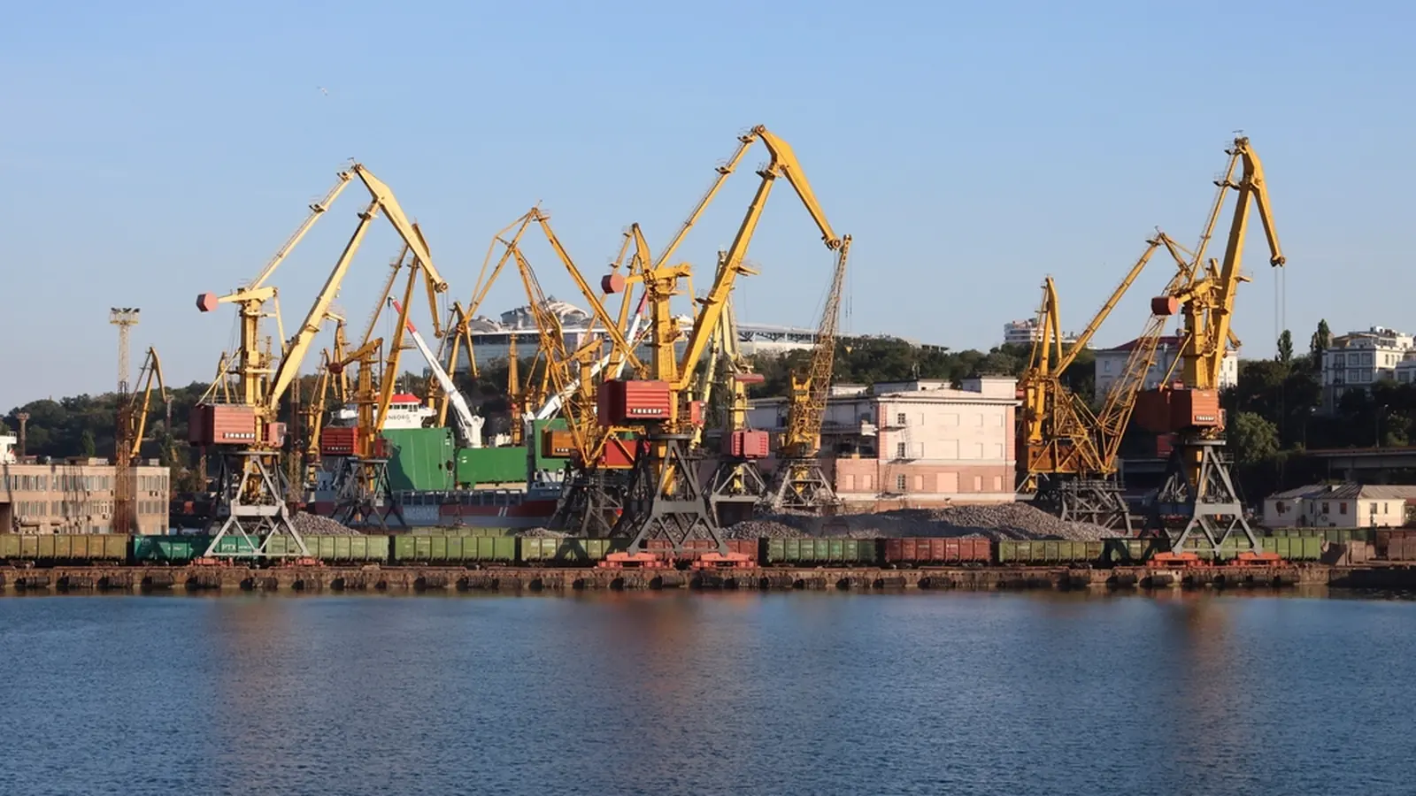 Harbour with yellow cranes along the quay under a blue sky