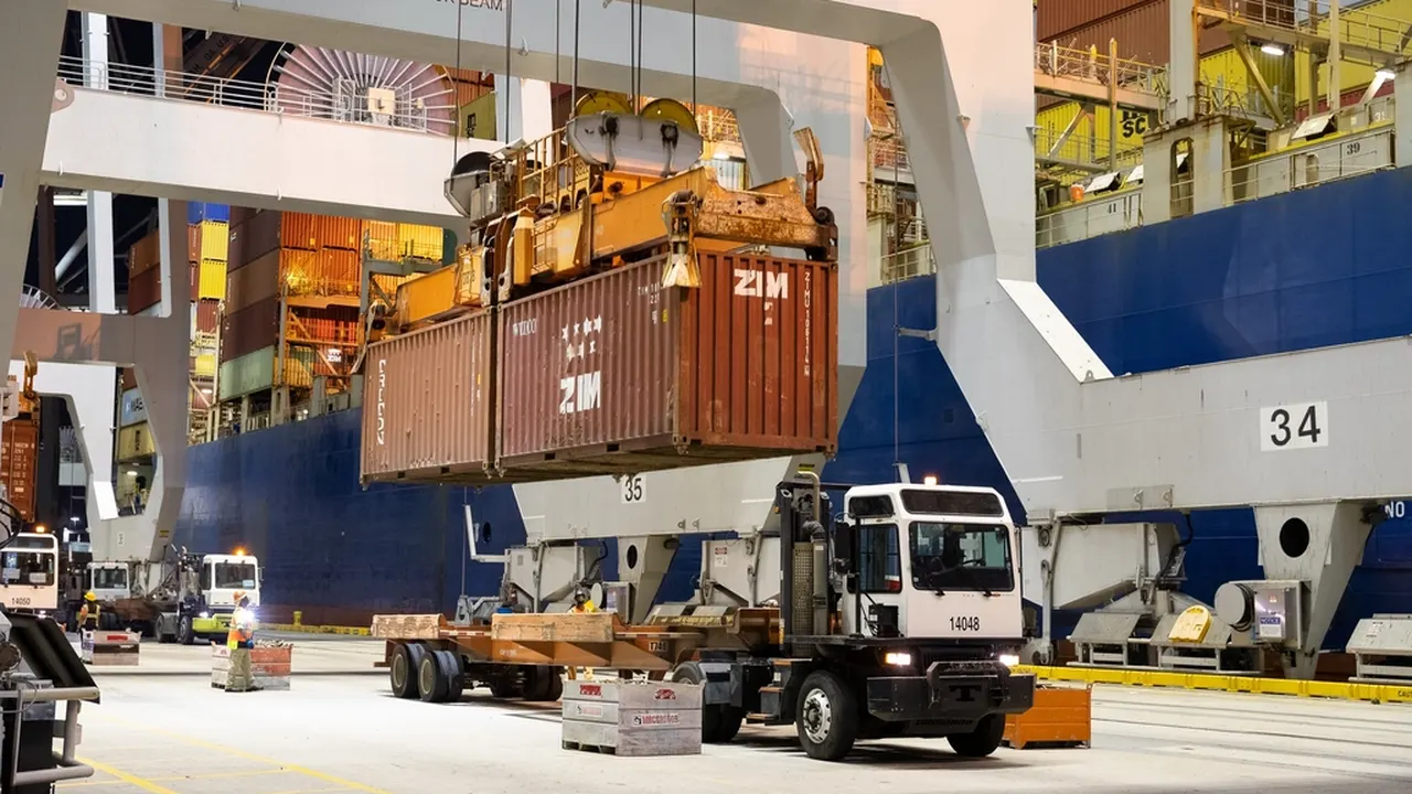 Container being loaded at a port with a truck below